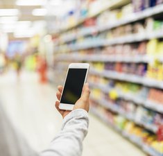 Close up of woman using her mobile in supermarket.