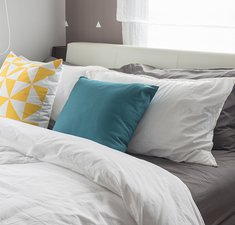 colorful pillows on white bed in modern bedroom